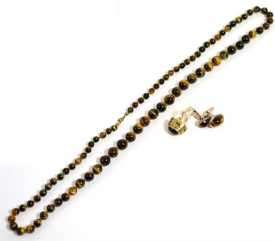 Lot 64 - A tiger's eye South African ring, finger size L, stamped '9ct'; a tiger's eye bead necklace, length