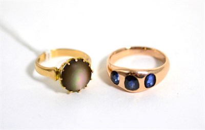 Lot 94 - A sapphire three stone ring, finger size N, stamped '15CT', and a mother of pearl ring, finger size