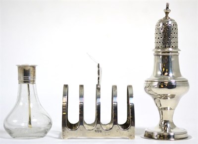 Lot 106 - A George III silver sifter, 1804; a silver toast rack, 1938; a silver mounted glass bottle...