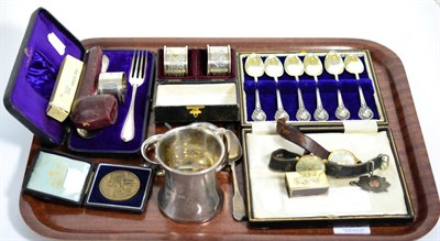 Lot 132 - A cased silver christening set, cased silver napkin rings, a christening mug, silver swizzle stick