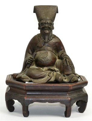 Lot 56 - A Chinese bronze figure of a seated sage on hardwood stand