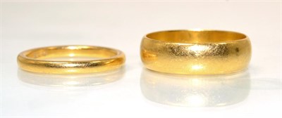 Lot 80 - A broad 22 carat gold band ring, finger size R and a narrow 22 carat gold band ring, finger...