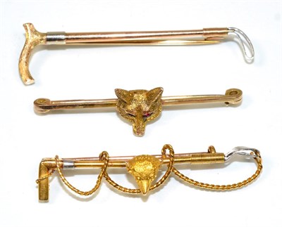 Lot 205 - A fox and crop brooch, a fox head to a crop bar, measures 5cm, stamped '15CT'; a fox head bar...