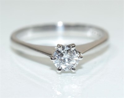 Lot 244 - An 18 carat white gold solitaire diamond ring, a round brilliant cut diamond in a claw setting,...