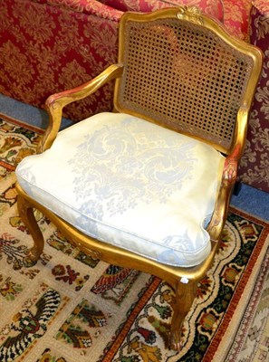 Lot 1183 - A reproduction gilt fauteuil with cane back and seat