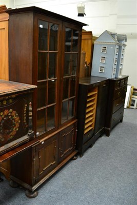 Lot 1221 - An early 20th century panelled and glazed oak bookcase cabinet with copper strapwork hinges