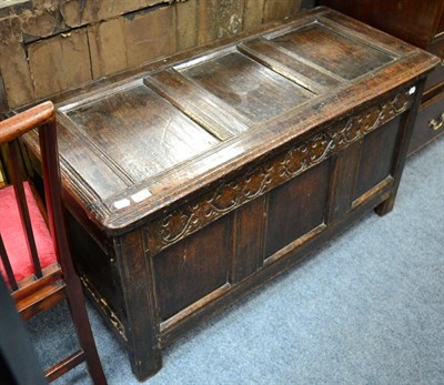 Lot 1239 - An early 18th century oak three panelled coffer with hinged lid, carved frieze and stile ends