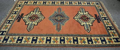 Lot 1251 - A Kozak rug, West Anatolia, the terracotta field with three medallions enclosed by ivory...