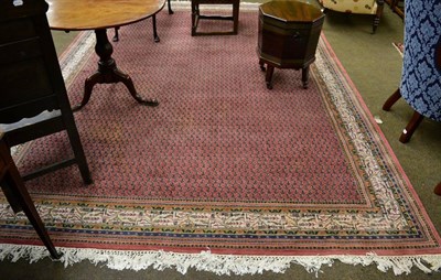 Lot 1257 - An Indian carpet,of Serabend design, the coral pink field of boteh, enclosed by ivory borders,...