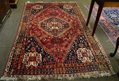 Lot 1259 - A Persian Kashgai rug, South West Iran, the madder field with an indigo central medallion,...