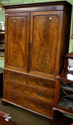 Lot 1275 - A George III mahogany linen press, the upper section fitted with two dressing slides and a...