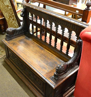 Lot 1323 - A carved oak box settle with dolphin form arms