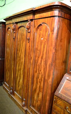 Lot 1387 - A large Victorian mahogany triple wardrobe, moulded cornice over three panelled doors, fitted...