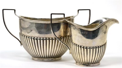 Lot 14 - A silver cream jug and sugar bowl, Henry Moreton, Birmingham 1914, oval part fluted form, the sugar
