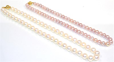 Lot 103 - A cultured pearl necklace, uniform cultured pearls knotted to a ball clasp, stamped '18K',...