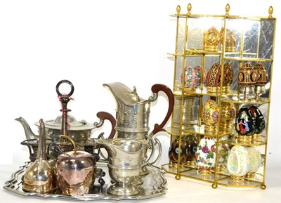 Lot 134 - ~ A hammered pewter tea and coffee set, together with decorative eggs on a gilt and glass...