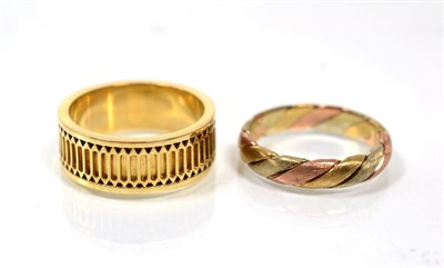 Lot 171 - A 9 carat gold band ring, with pierced motif, finger size U and a 9 carat three colour gold...
