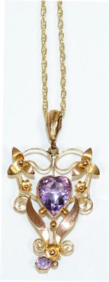 Lot 212 - An early twentieth century amethyst pendant, on chain, a heart cut amethyst within a floral...