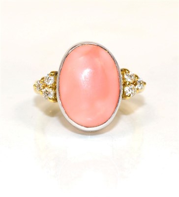 Lot 213 - An 18 carat gold coral and diamond ring, an oval coral in a rubbed over setting, spaced by...