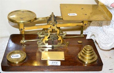 Lot 272 - ~ A set of brass desk scales and weights on an oak plinth