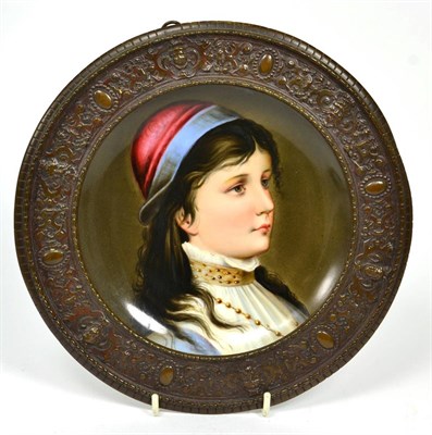 Lot 290 - A Continental circular plaque decorated with a young girl in a cast metal frame