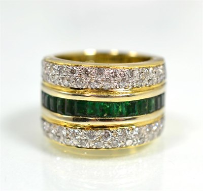 Lot 439 - An emerald and diamond ring, a central band of channel set calibré cut emeralds between bands...