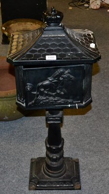 Lot 1193 - A black painted cast pedestal letter box, decorated with huntsmen and horns