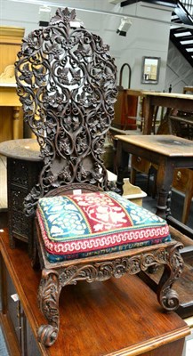 Lot 1255 - A 19th century Bombay black wood high back chair with intricately carved and pierced foliate...