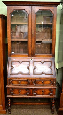 Lot 1295 - A carved oak bureau bookcase