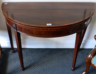 Lot 1358 - ~ A Georgian mahogany fold over demi-lune card table