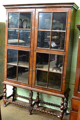 Lot 1449 - Walnut glazed bookcase on stand with twin locks and boldly turned stretchers