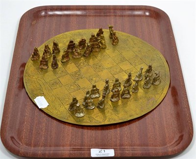 Lot 21 - An Oriental cast brass and silvered chess set, with circular engraved brass board, the pieces...