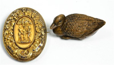 Lot 99 - A silver gilt brooch decorated with Adam and Eve together with a carved wooden Japanese netsuke...