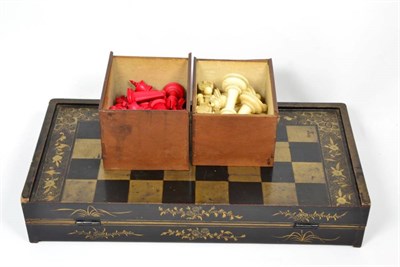 Lot 189 - An early 20th century lacquer folding chess/games box and an ivory chess set