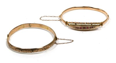 Lot 282 - A late nineteenth century ruby bangle, graduated round cut rubies to a lozenge shaped plaque in...