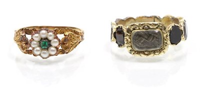 Lot 302 - A garnet mourning ring, a central glazed plaque containing hairwork within a floral border, to...