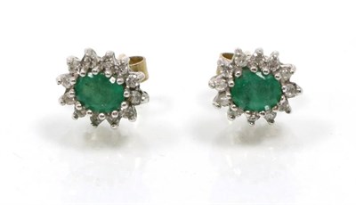 Lot 304 - A pair of 9 carat gold emerald and diamond cluster earrings, oval cut emeralds within a border...