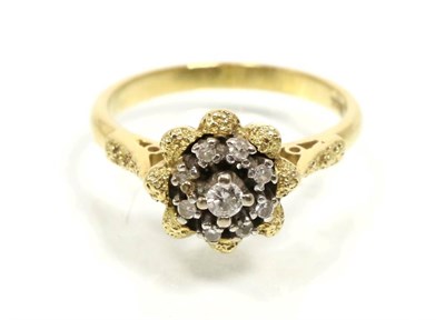 Lot 309 - A diamond cluster ring, round brilliant cut diamonds in a claw settings, to a textured frame...