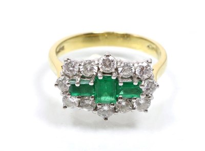 Lot 310 - An 18 carat gold emerald and diamond cluster ring, three baguette cut emeralds within a border...