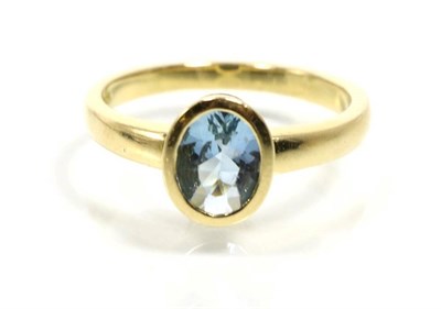 Lot 326 - An 18 carat gold aquamarine ring, an oval cut aquamarine in a rubbed over setting, finger size O