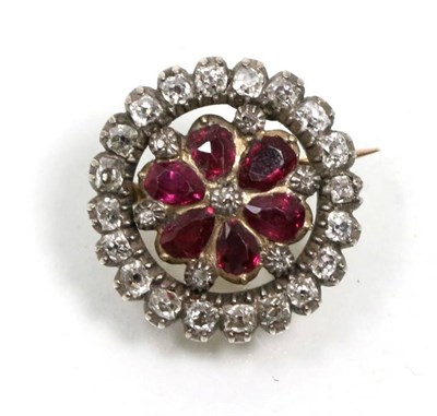 Lot 327 - A ruby and diamond brooch, a central old cut diamond within a border of pear cut rubies and an...