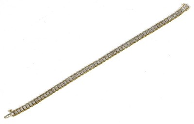 Lot 401 - A diamond line bracelet, round brilliant cut diamonds in claw settings, to two colour bar...