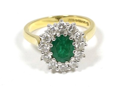 Lot 423 - An 18 carat gold emerald and diamond cluster ring, an oval cut emerald within a border of round...