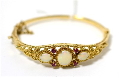 Lot 4 - A 9 carat gold opal and ruby bangle
