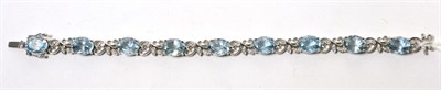 Lot 29 - An aquamarine and diamond bracelet, oval cut aquamarine in claw settings, spaced by diamond set...