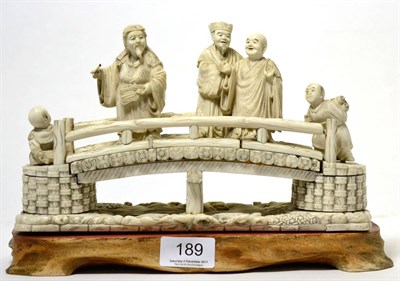 Lot 189 - A Japanese Meiji period ivory figure group of figures on a bridge, inlaid to the base with a signed