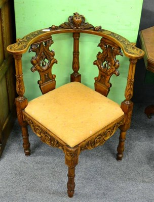 Lot 1254 - A carved oak corner chair