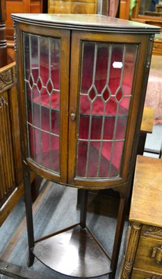 Lot 1276 - ^ A bow fronted standing corner display cabinet with leaded glass doors and a shelf stretcher