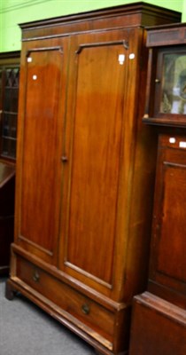 Lot 1372 - A mahogany double wardrobe fitted with a base drawer