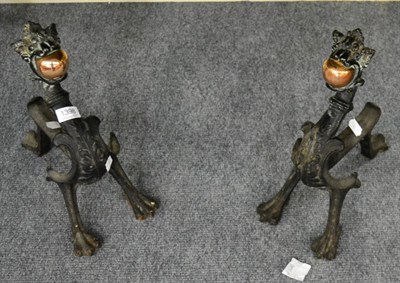 Lot 1398 - ^ A pair of Victorian cast iron andirons in the form of dragons holding copper spheres between...